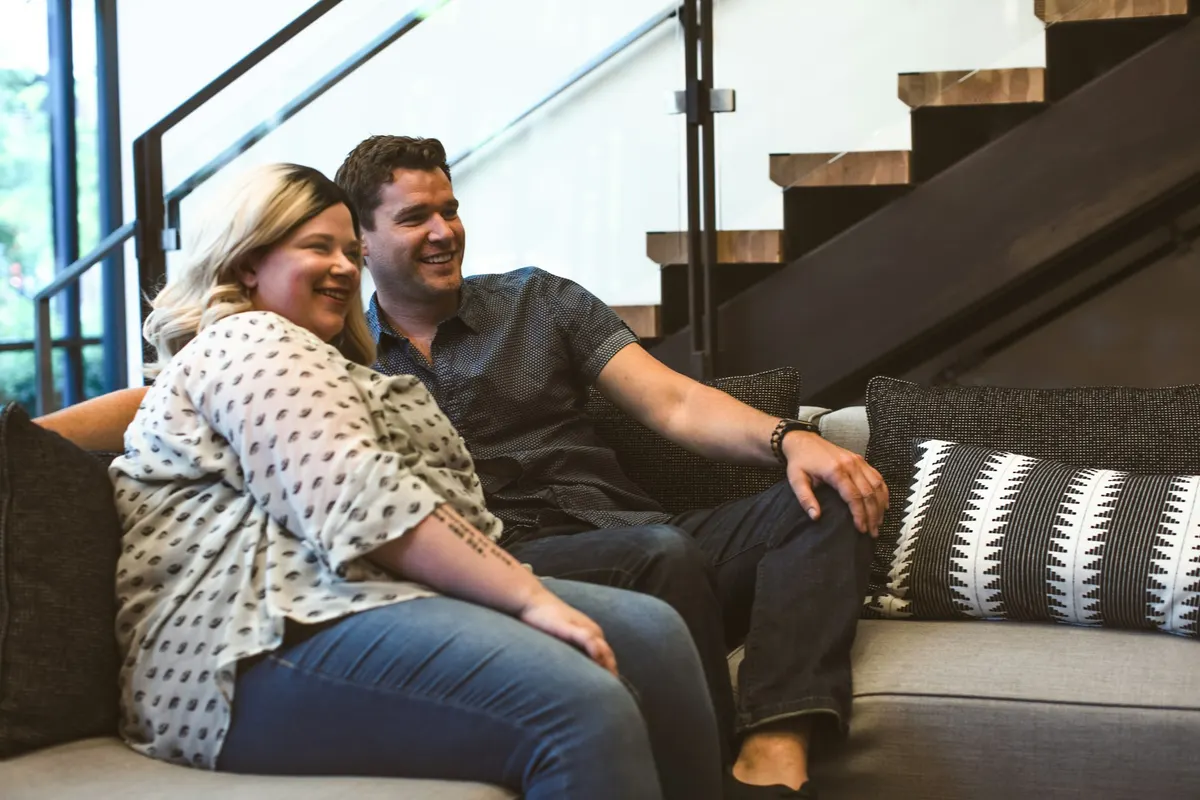 A couple smiling on the sofa as they play
